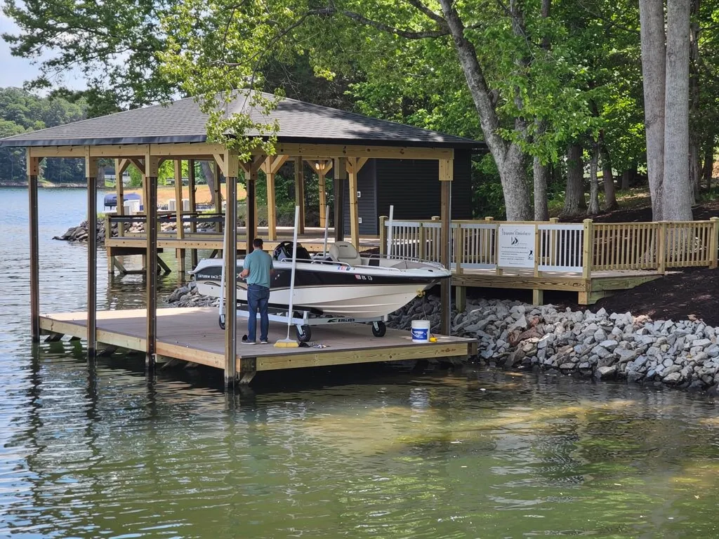 Technician inspecting a boat lift cable and motor for maintenance