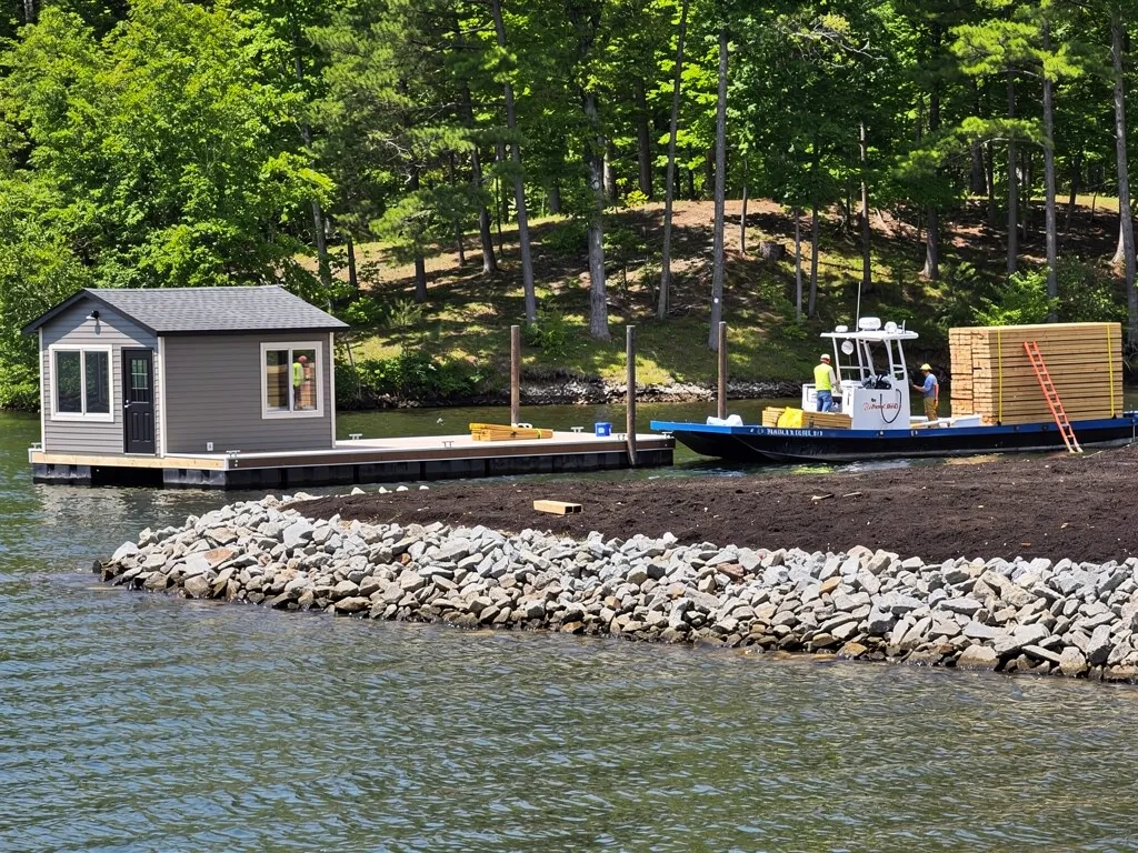 Barge-mounted crew installing dock pilings near a Bumpass shoreline