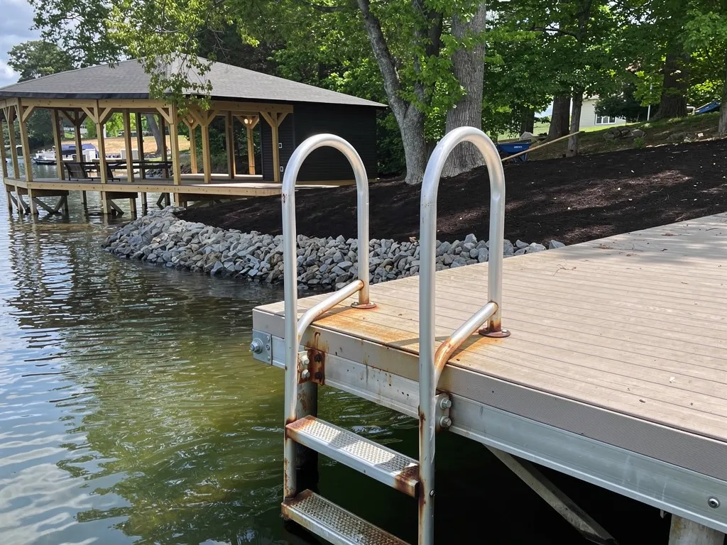 Rusted dock ladder rungs and loose mounting bracket on a lake dock